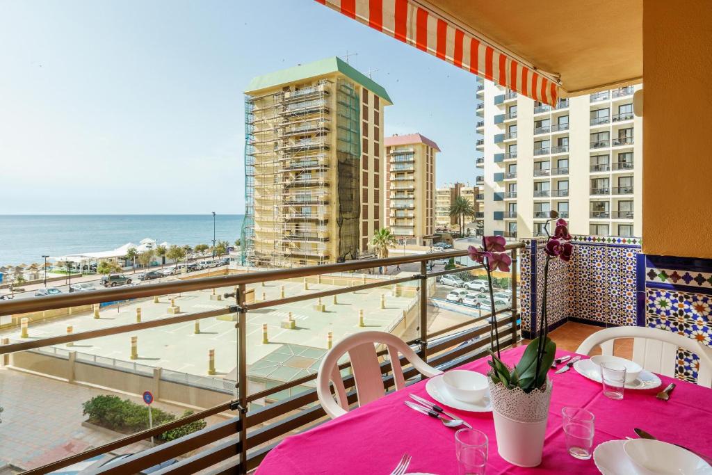 een balkon met een tafel en stoelen en uitzicht op het strand bij Ubicación magnífica, zona tranquila in Fuengirola