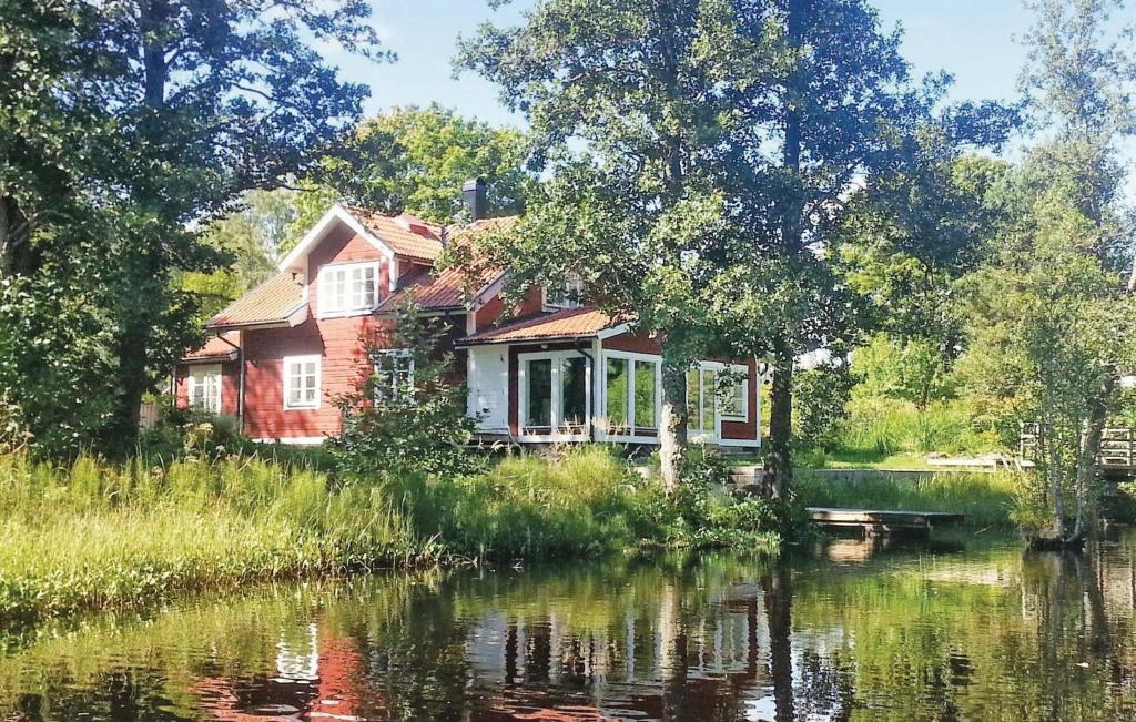 une maison à côté d'une rivière avec des arbres et de l'eau dans l'établissement Gorgeous Home In Kopparberg With Wifi, à Kopparberg