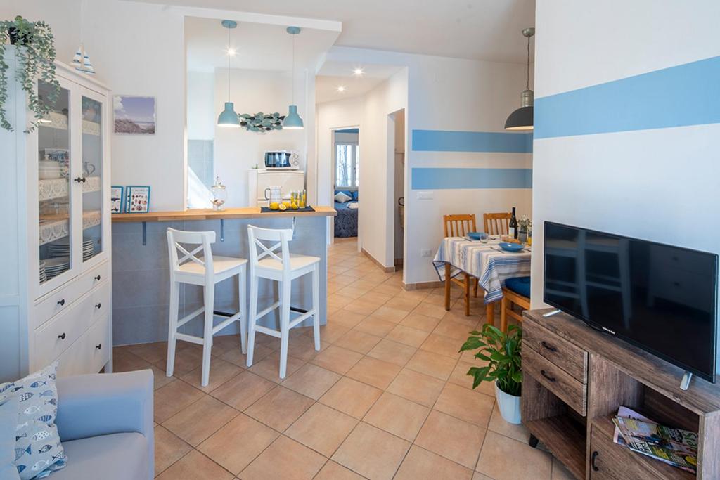 cocina y sala de estar con sofá y TV. en Nel verde a due passi dal mare en Lido di Spina