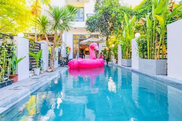 uma piscina com uma piscina insuflável cor-de-rosa em Kim Phu Villa Hoi An em Hoi An