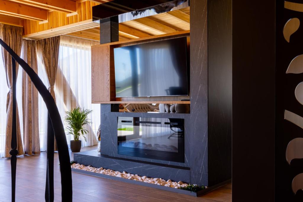 ein Wohnzimmer mit einem TV an der Wand in der Unterkunft Batllava Premium Resort Villa 1 in Orllan