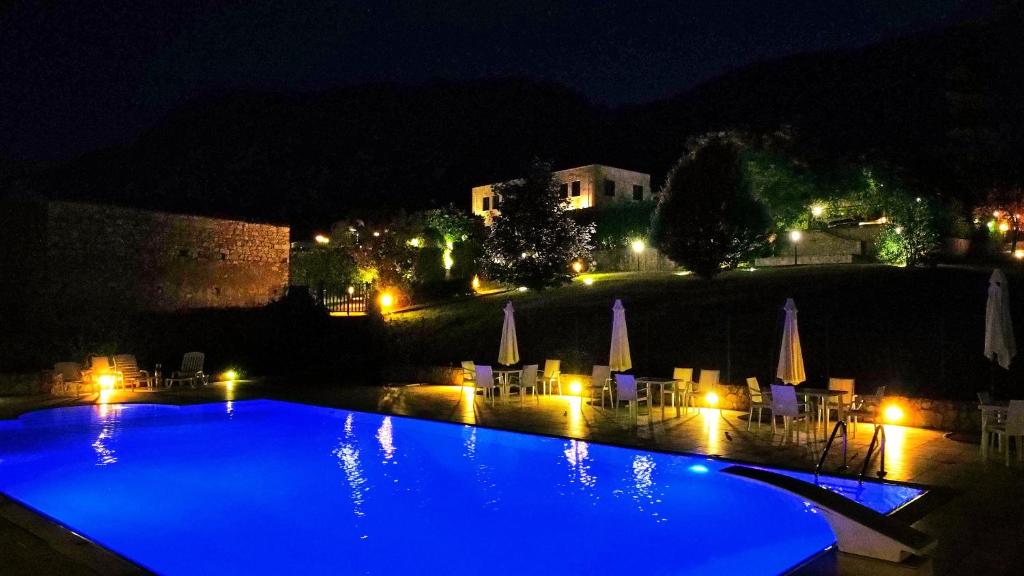 a large blue swimming pool at night with lights at Sotto Il Cielo Hotel in Pignola