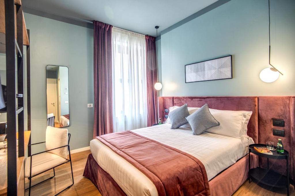 ein Hotelzimmer mit einem Bett und einem Stuhl in der Unterkunft Sheva Boutique Hotel in Mailand