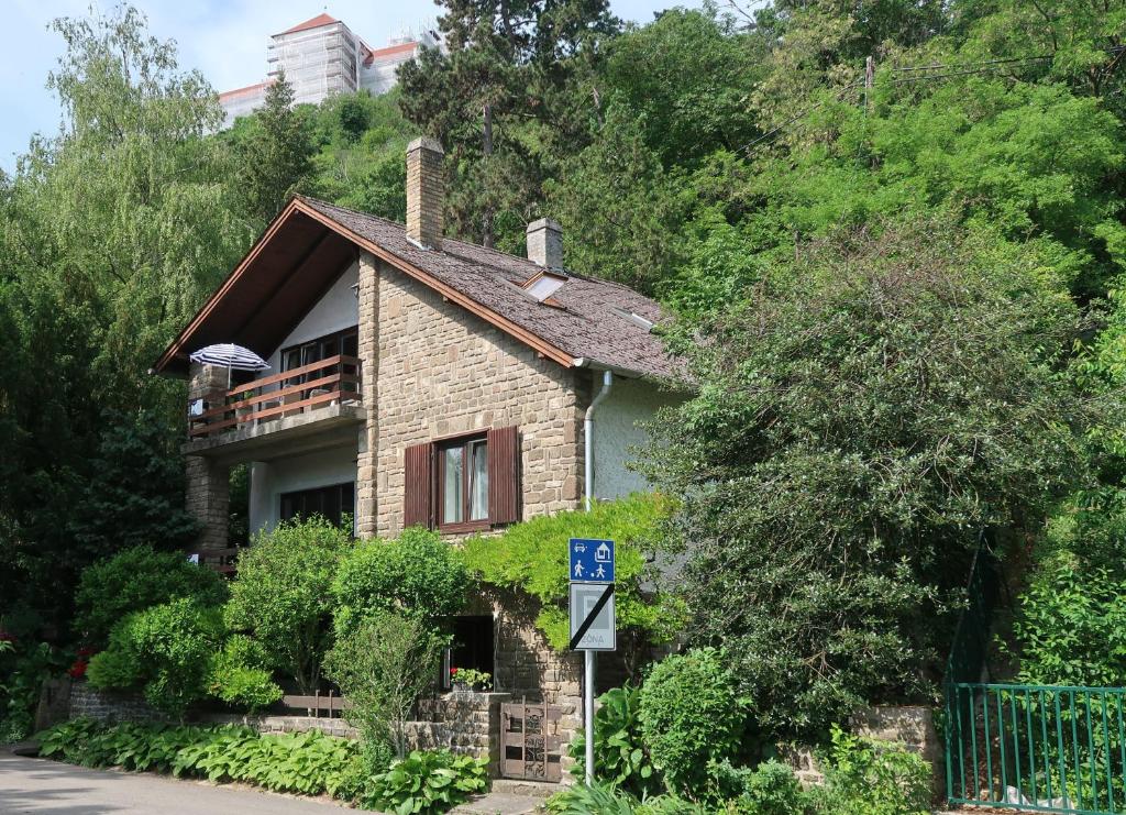 a brick house with a sign in front of it at Váralja Vendégház Tihany in Tihany