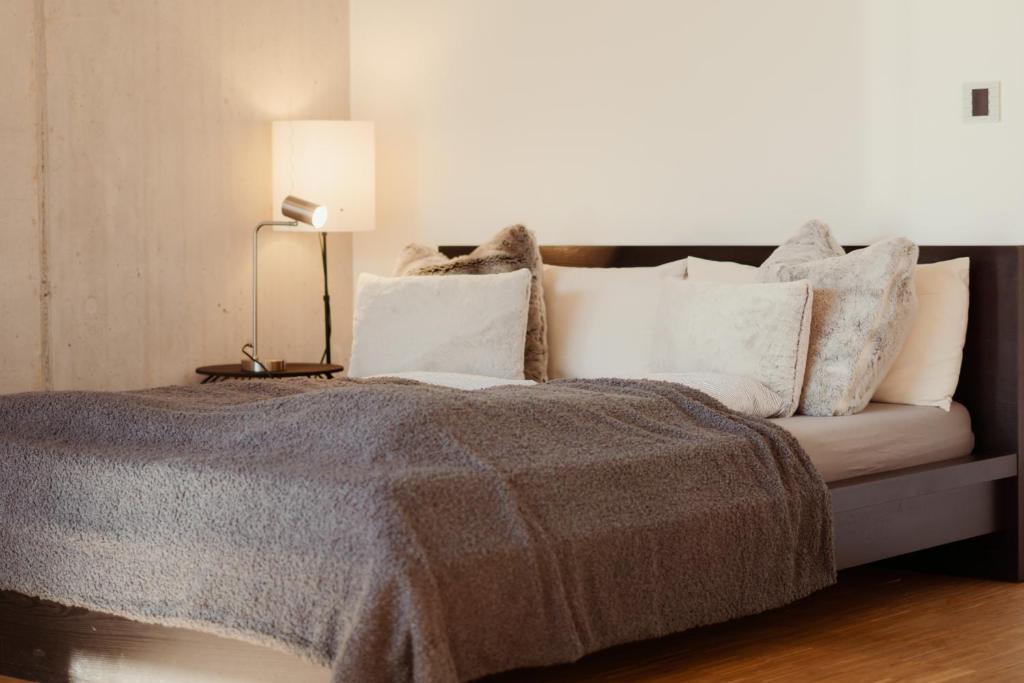 a bedroom with a bed with pillows and a lamp at Loft-Apartment - Bestlage am Kurpark mit Terrasse - kostenloses Parken - Küche - Netflix - Waschmaschine in Wiesbaden