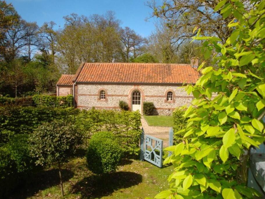 ein altes Steinhaus mit rotem Dach in der Unterkunft The Engine House in East Dereham