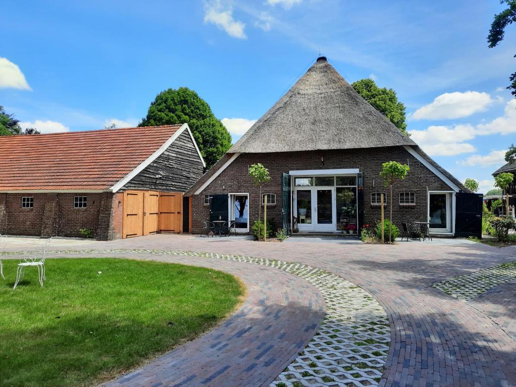 een groot bakstenen gebouw met een rieten dak bij De Mussenhof in Westdorp