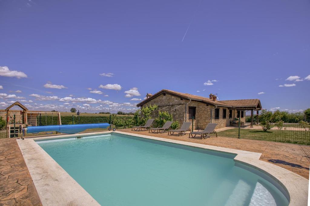 a large swimming pool in a yard with a house at Casa Xabelen Etxea in Fresno de Cantespino