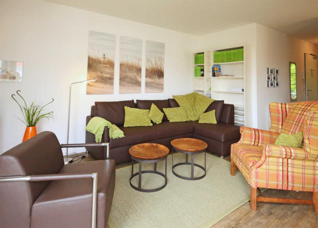 a living room with a brown couch and two chairs at Haus Meeresblick - Ferienwohnung Strandburg B 1.02 (Ref. 136069) in Baabe