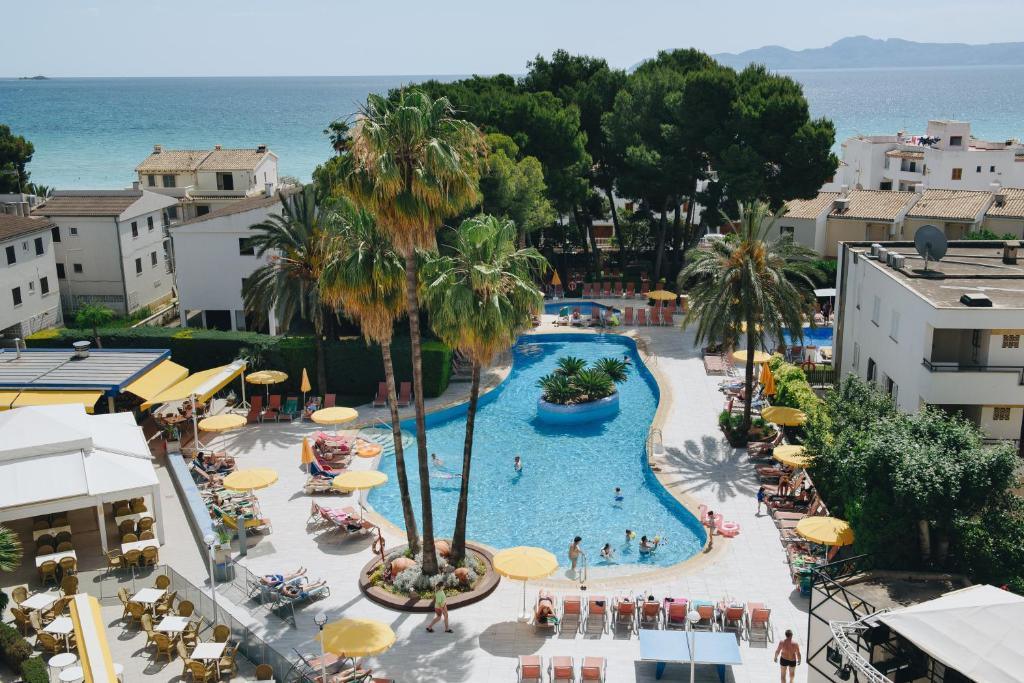 una vista aérea de una piscina con sombrillas en Hotel Ivory Playa Sports & Spa, en Puerto de Alcudia