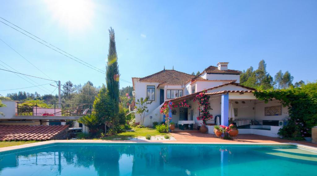 uma casa com uma piscina em frente em Adore Portugal Lousã Casa Rural 2 Suites em Lousã