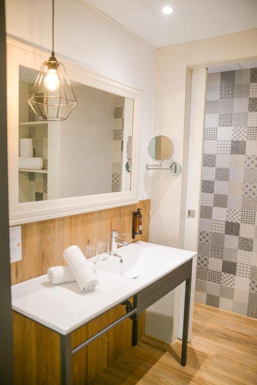a bathroom with a sink and a mirror at Lloret Vibe Affiliated by FERGUS in Lloret de Mar