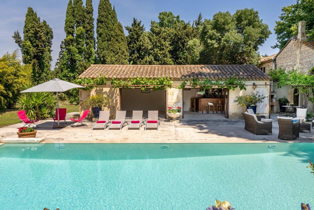 une maison avec une piscine dans une cour dans l'établissement Mas des Fontètes, à Fontvieille