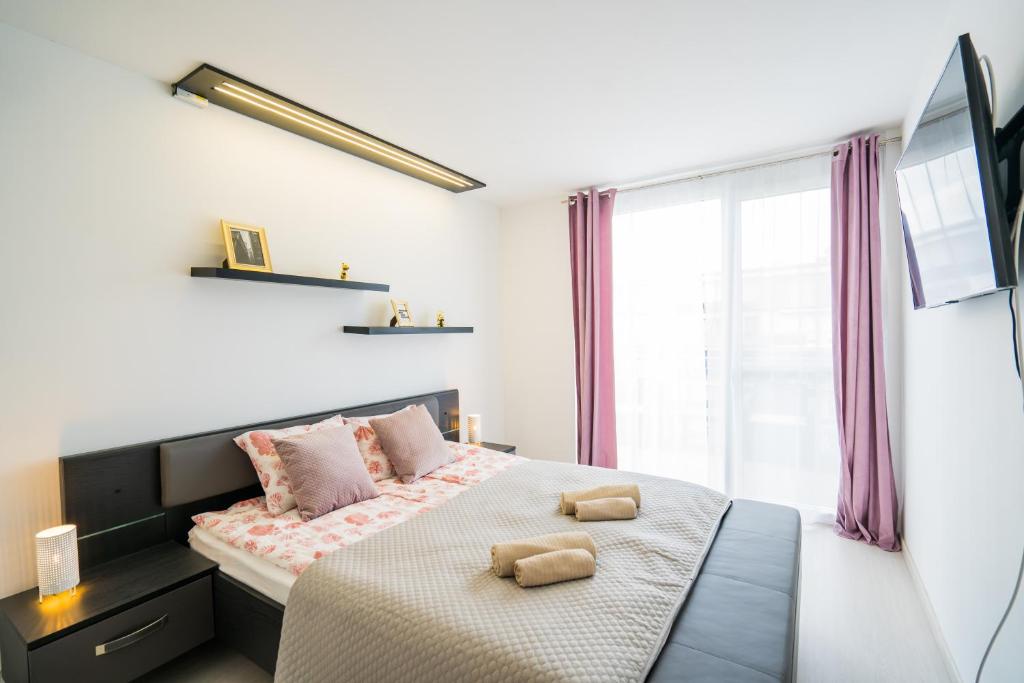 A bed or beds in a room at Andante Panoráma Apartman