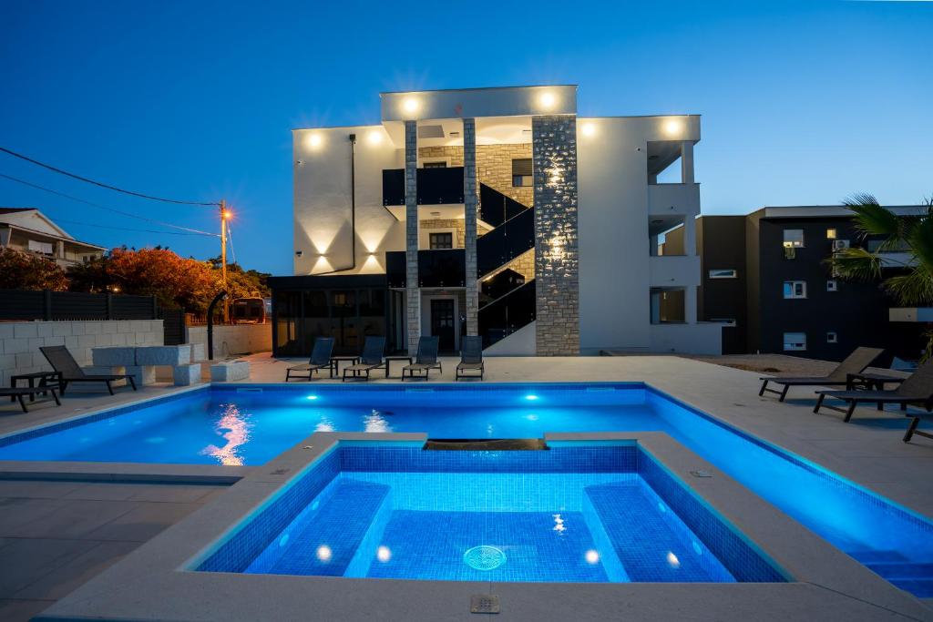 a swimming pool in front of a building at night at The Princess in Novalja