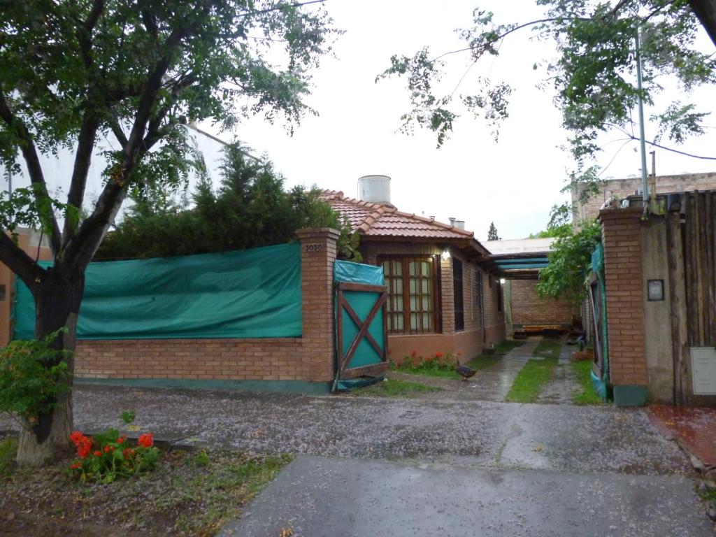 Una casa con una lona verde a un lado. en Casa en el Challao en Mendoza