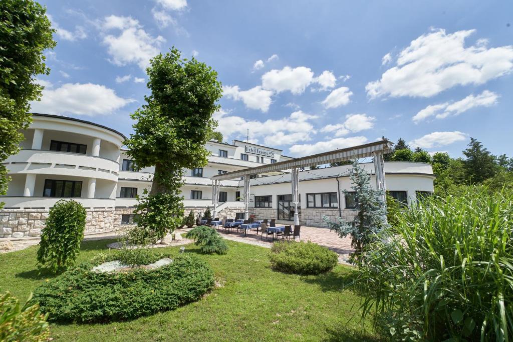 vista esterna di un edificio con giardino di Hotel Korona a Harkány