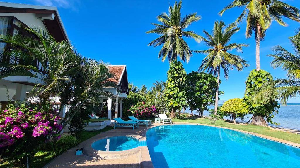 a villa with a swimming pool and palm trees at Laemsor Residence in Laem Sor