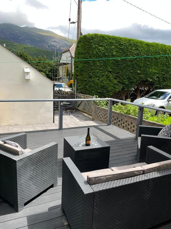 a patio with a table and a bottle of wine at 4-6 Guests in centre location with stunning views in Llanberis