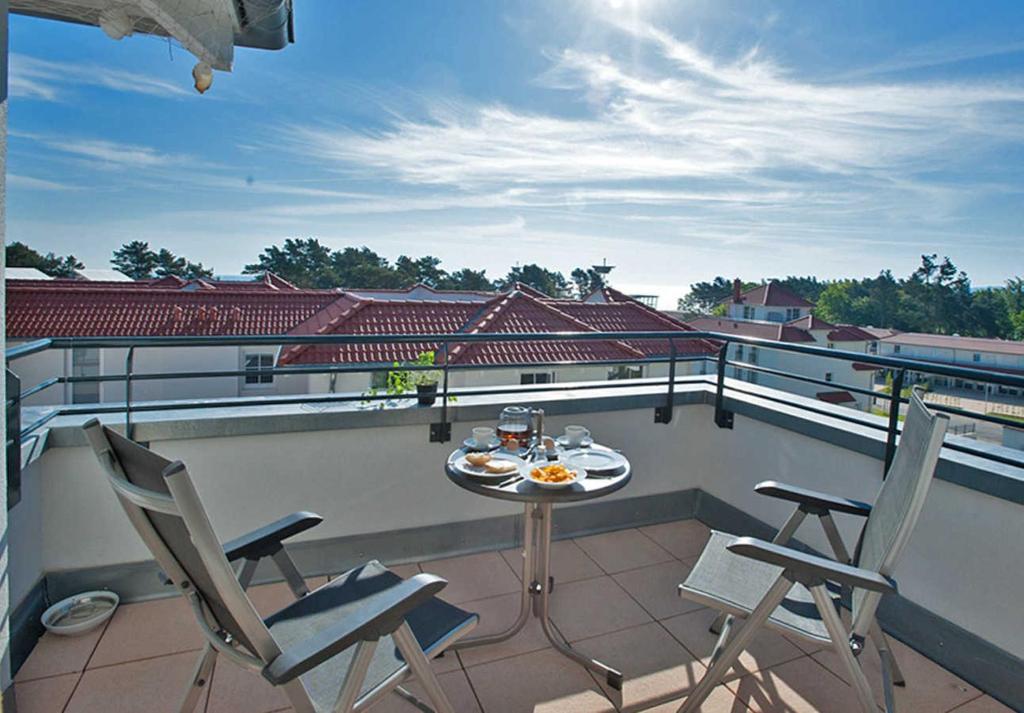 ein Balkon mit Tisch und Stühlen auf einem Dach in der Unterkunft Haus Meeresblick - Ferienwohnung Suedost A 4.05 (Ref. 128720) in Baabe