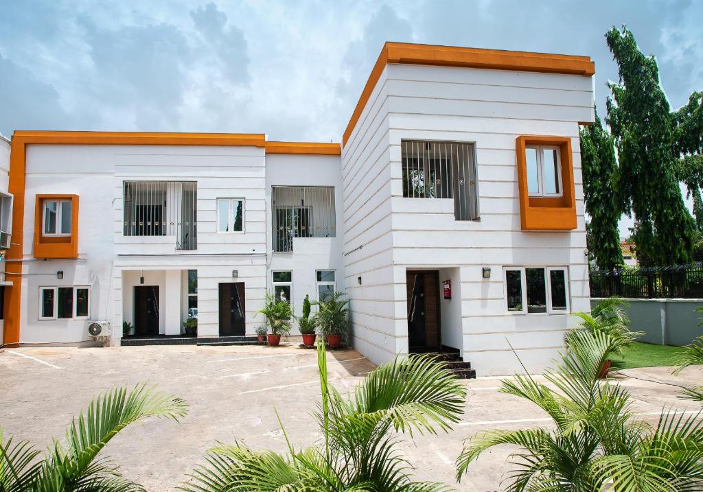 una casa blanca con acentos naranjas en Orange Roof Lodge, en Abuja