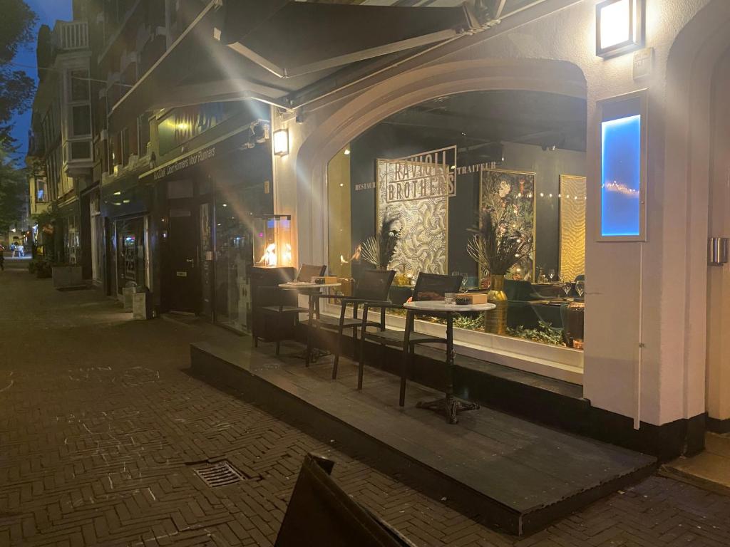 ein Lagerfenster mit Tischen und Stühlen in einer Straße in der Unterkunft Boutique Hotel Ravioli Brothers in Den Haag