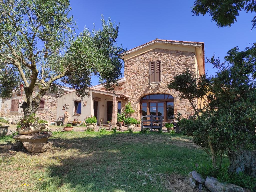 an old stone house with a yard at Agriturismo Gragonti, Arbus Costa Verde in Arbus