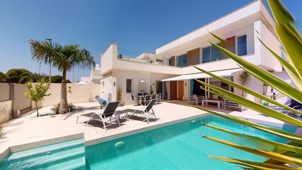 a villa with a swimming pool and a house at Villa Higinio - A Murcia Holiday Rentals Property in Santiago de la Ribera