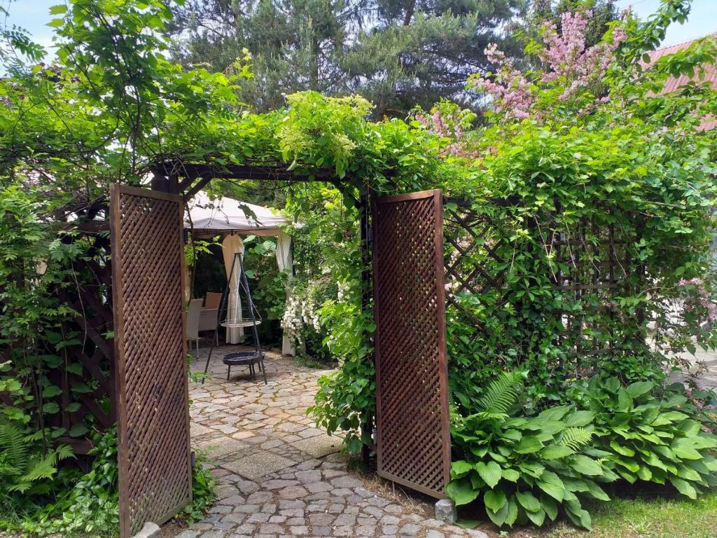 an entrance to a garden with a wicker gate at Fitness - domek z ogródkiem in Stegna