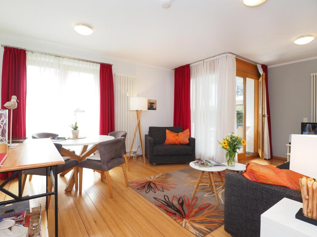 a living room with a couch and a table at Kaiservillen Heringsdorf - Ferienwohnung mit 1 Schlafzimmer und Terrasse D201 in Heringsdorf