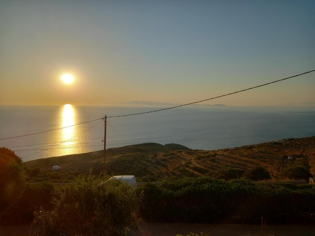 a sun setting over the ocean on a hill at Madilida Sifnos Apartment in Artemonas