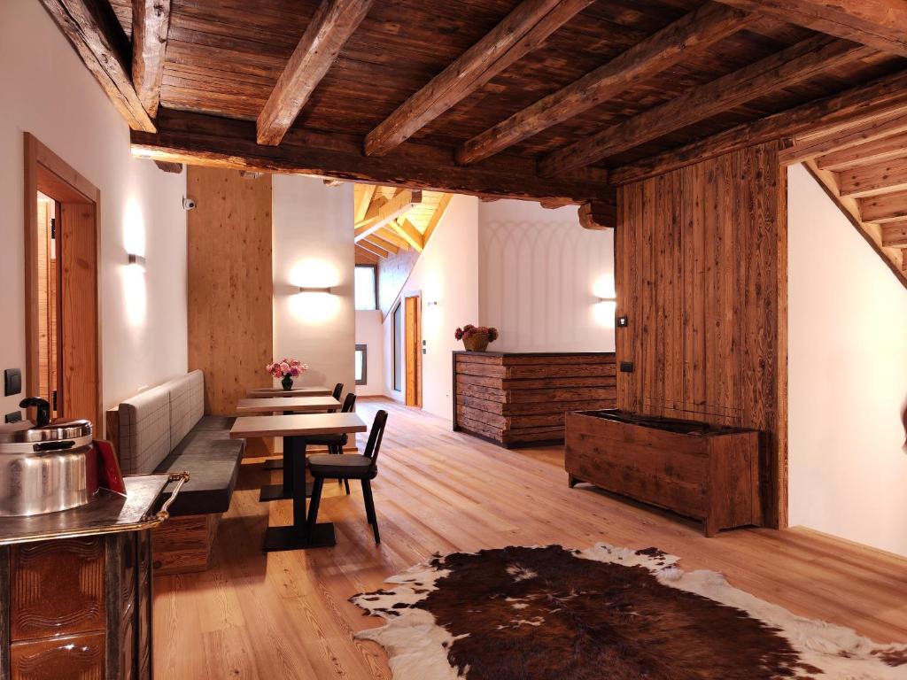 uma sala de estar com tectos em madeira e uma mesa em Agritur Fioris em Nanno