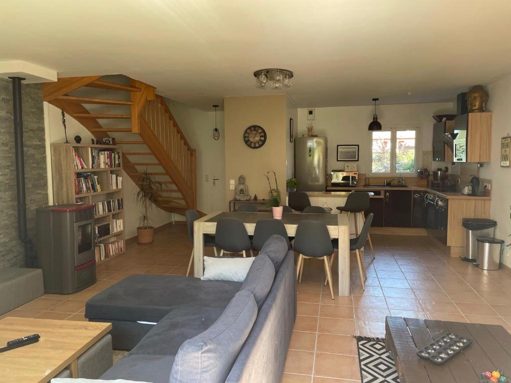 ein Wohnzimmer mit einem Sofa und einem Tisch sowie eine Küche in der Unterkunft Maison au cœur du Pays Basque in Cambo-les-Bains