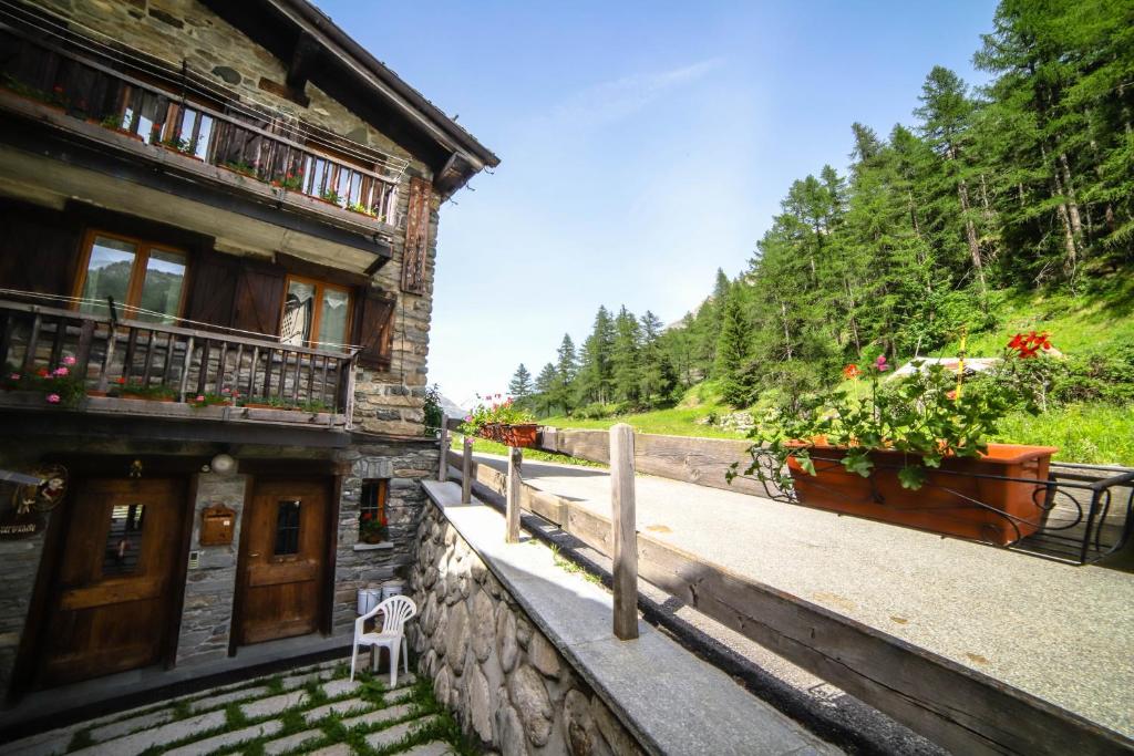 a building with a white chair sitting outside of it at Antica casa di montagna Maison Bovard in Valgrisenche