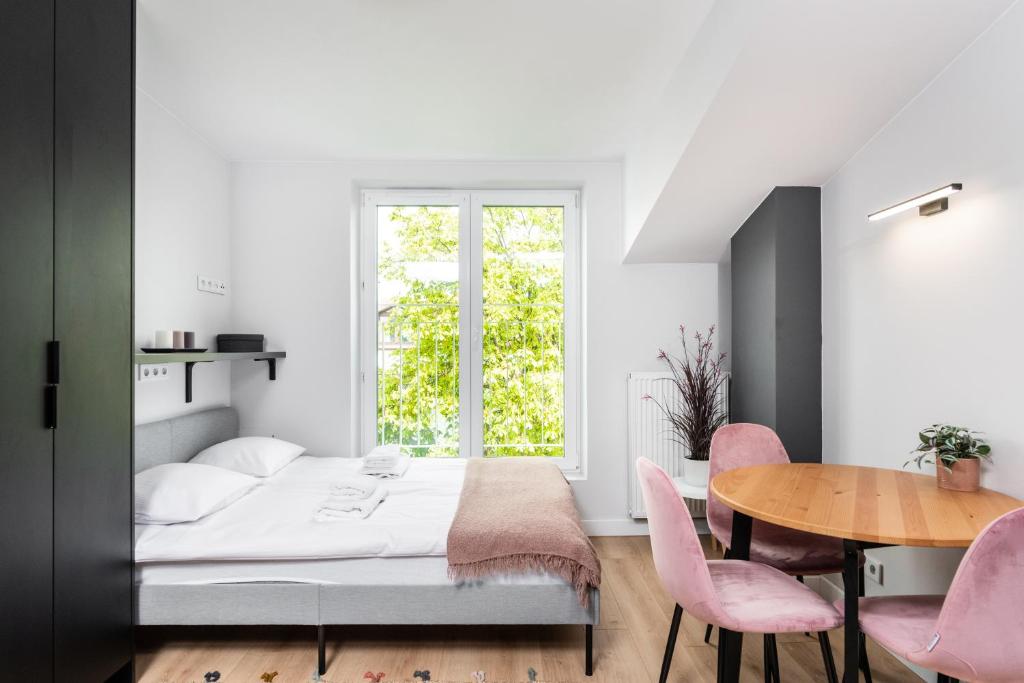 a bedroom with a bed and a table and chairs at Smart Apartments - Old Town & Main Train Station in Krakow