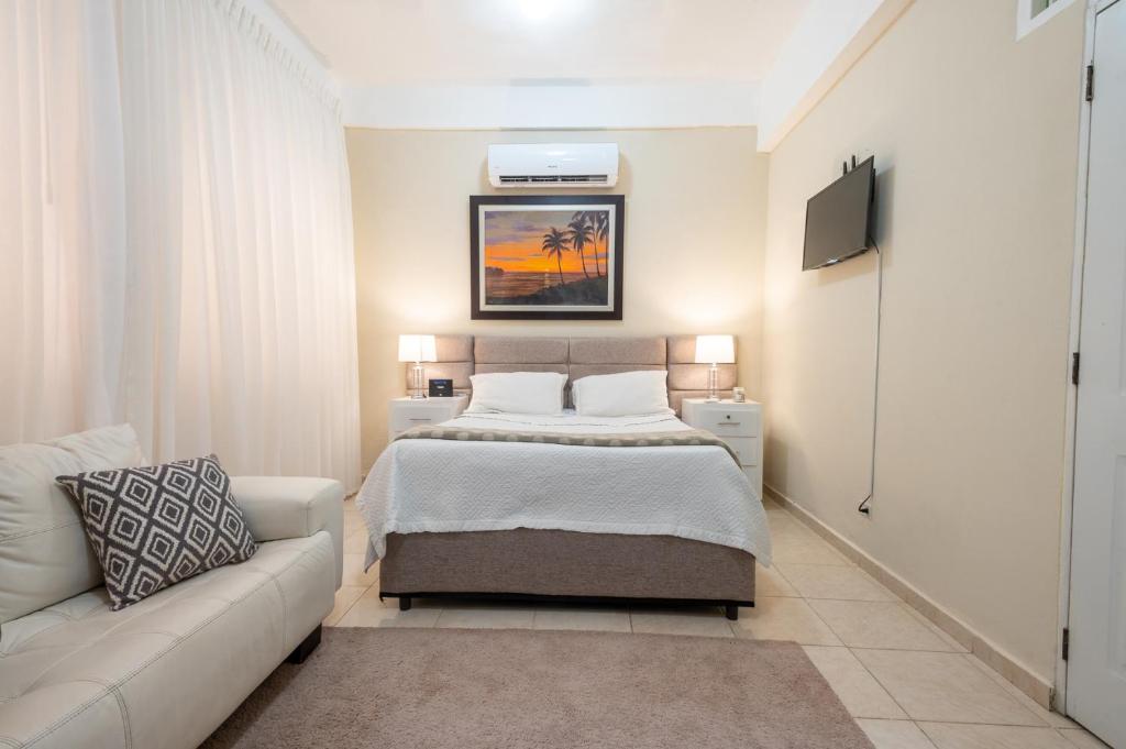 a bedroom with a bed and a couch at Acogedor estudio 7 en la Zona Colonial in Santo Domingo