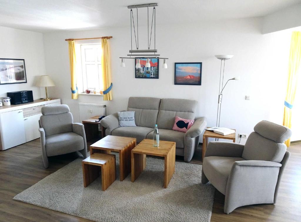 ein Wohnzimmer mit einem Sofa, Stühlen und einem Tisch in der Unterkunft Inselresidenz Strandburg Juist - Turmwohnung 205 (Ref. 50959) in Juist
