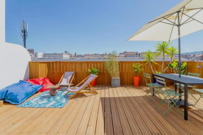 a patio with a table and chairs and an umbrella at STUDIO ** ROOFTOP ** LULLI in Marseille