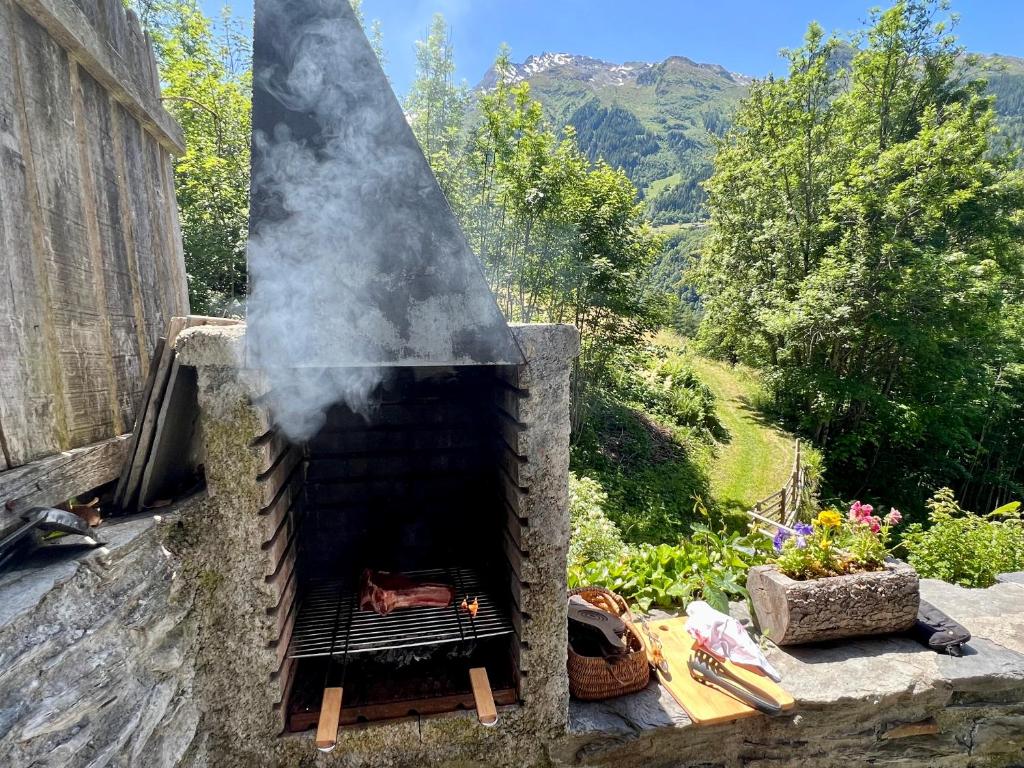 a stone oven with smoke coming out of it at Chalet Altus in Sainte-Foy-Tarentaise