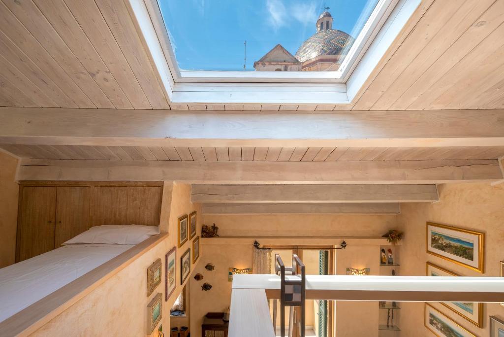 a loft bed in a room with a skylight at Casa Ferret. Appartamento nel cuore di Alghero in Alghero