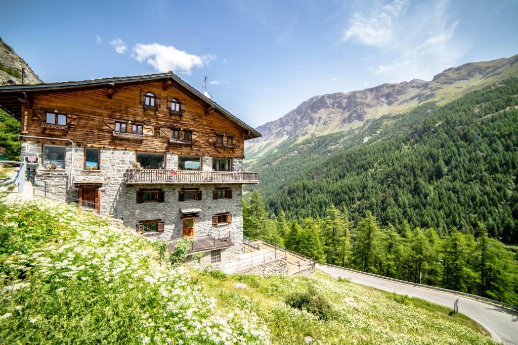 un antiguo edificio en el lado de una montaña en Hotel & Restaurant Perret - Mountain People, en Valgrisenche
