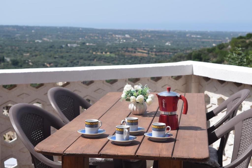 een houten tafel met koffiekopjes en een theepot erop bij Dimora in collina in Monopoli