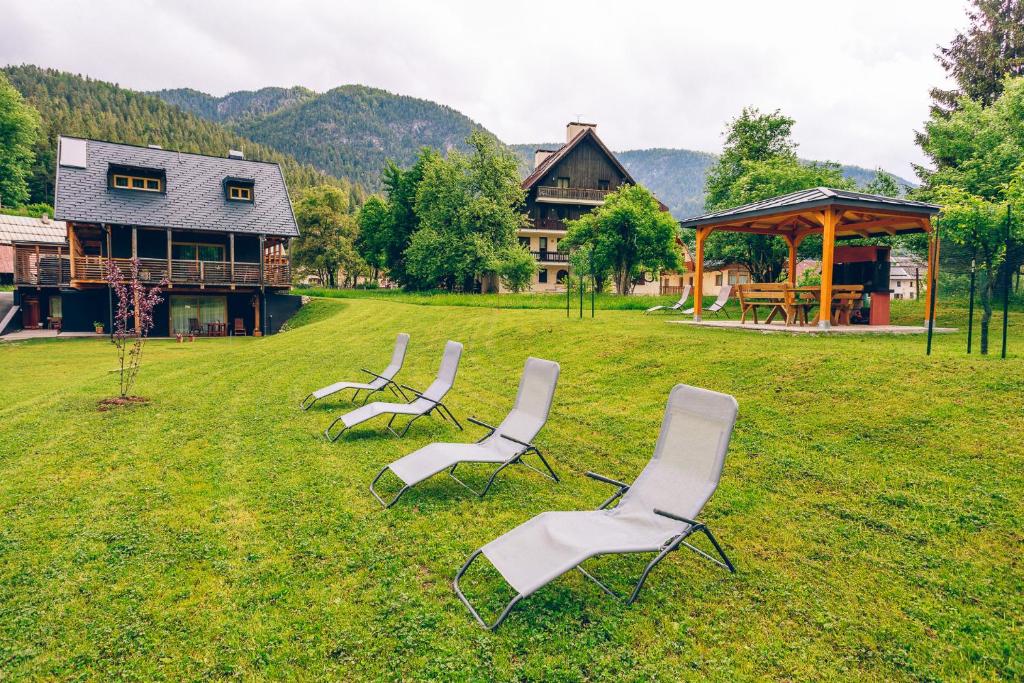 un gruppo di sedie seduti sull'erba di fronte a una casa di Chalet Valcanale a Camporosso in Valcanale