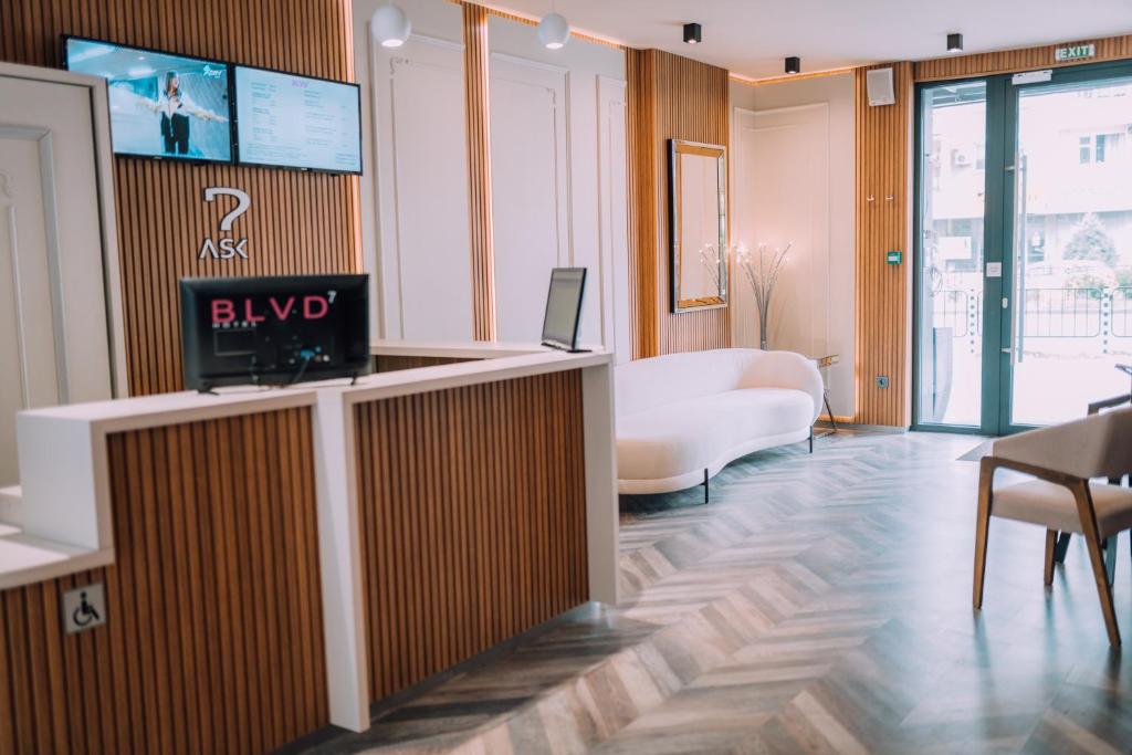 a lobby with a reception desk with a tv on the wall at Hotel BLVD 7 in Plovdiv