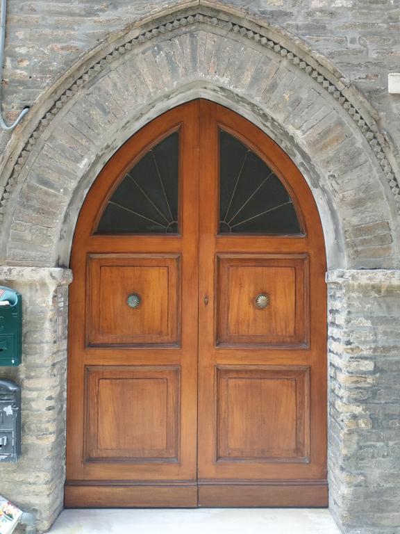 una puerta de madera en un arco de piedra en Appartamento Da Castlin en Fano