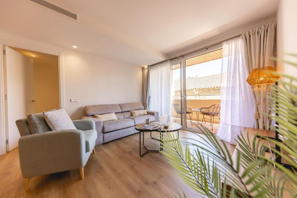 ein Wohnzimmer mit einem Sofa und einem Tisch in der Unterkunft Bravissimo Domènica, 2 bedrooms and balcony in Girona