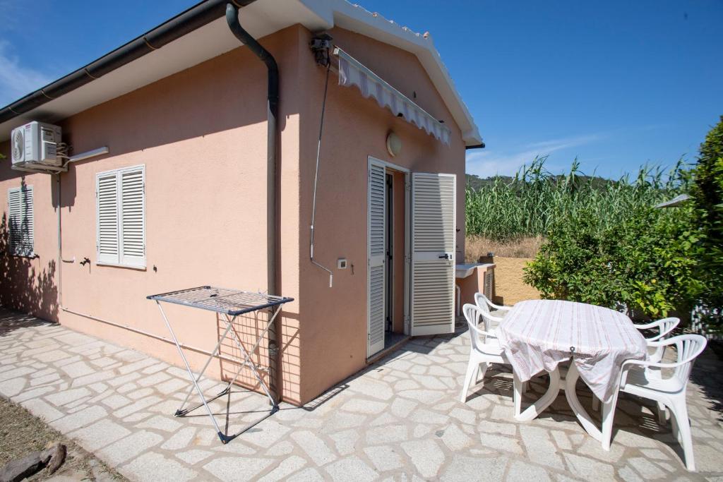 eine Terrasse mit einem Tisch und Stühlen vor einem Gebäude in der Unterkunft Casa Michelina - Goelba in San Mamiliano