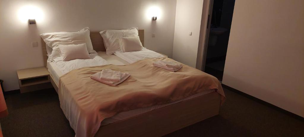 a bedroom with a bed with two towels on it at Vila Iulia in Baile Unu Mai
