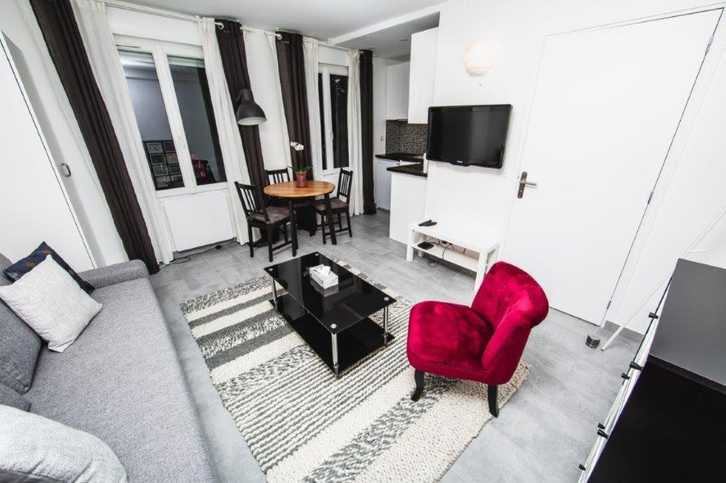 sala de estar con sofá y silla roja en Paris City Flat Studio 21 M carrée 103 Grd Paris, en Alfortville