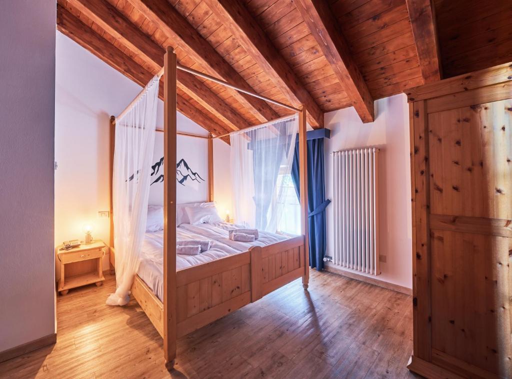 sypialnia z łóżkiem z baldachimem i oknem w obiekcie Hotel Bed & Bike Ledro w mieście Molina di Ledro